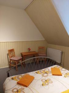 Dolní Žandov曼斯基德福尔旅馆的一间卧室配有带橙色毛巾的床