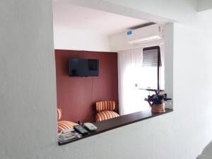 罗萨里奥Como en Casa的一间房间,配有两把椅子和墙上的电视