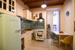 那不勒斯Casa Giolà的厨房配有冰箱和桌椅