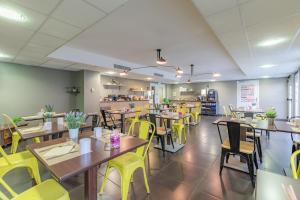 阿让Appart'City Confort Agen Centre的用餐室配有木桌和黄色椅子