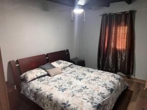 Los Altos de Cerro AzulCasa de campo en Panamá的一间卧室设有一张床和一个窗口