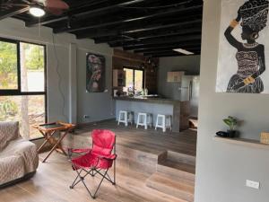 Los Altos de Cerro AzulCasa de campo en Panamá的一间带红色椅子的客厅和一间厨房