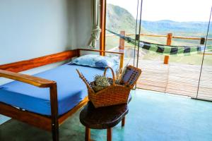 圣若热岛ninho da arara的一间卧室配有一张床和一个椅子篮子