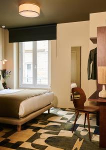 圣马洛卡地亚酒店的一间卧室设有一张床、一个窗口和一把椅子