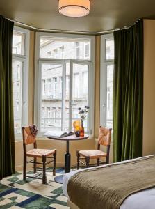 圣马洛卡地亚酒店的一间卧室配有桌子、两把椅子和窗户