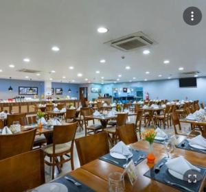 马瑙斯#SENSACIONAL# PREMIUM HOTEL Manaus AM的一间带木桌椅的餐厅和一间房间