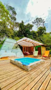 MacasMacas Glamping的一个带游泳池和房子的木甲板
