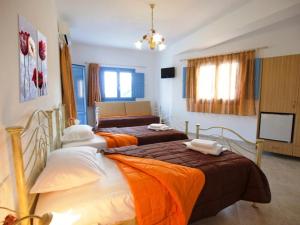 迈洛波塔斯伊奥斯记忆旅馆的配有电视的客房内的两张单人床