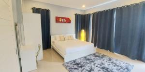 邦涛海滩Patrick villa phuket的一间卧室配有一张带蓝色窗帘和地毯的床