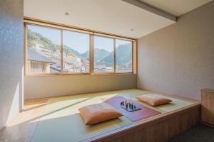 神户HOTEL ALGO的客房设有带2个枕头的床和窗户。