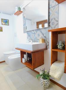 蒙塔尔奇诺Otello Guest House的一间带水槽、卫生间和镜子的浴室