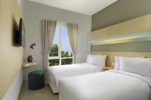 登巴萨吉兹会议酒店的配有窗户的酒店客房内的两张床