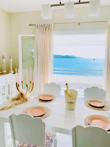 波多河丽Fairy home Porto Heli的一间带桌椅和大窗户的用餐室