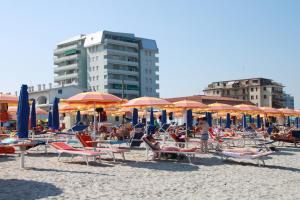 利多波波萨Eco del Mare Apartments的海滩上的一组椅子和遮阳伞