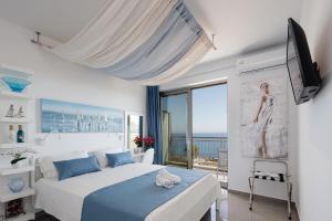 帕诺尔莫斯雷斯蒙Contessina del mare的一间白色卧室,配有床和阳台