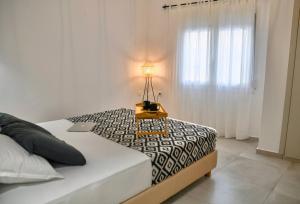 阿基欧斯尼古拉斯Casa De Lago的一间卧室配有一张带台灯的桌子和一张床