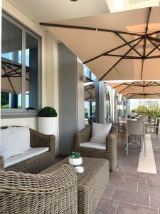 米拉波皮酒店的一个带柳条椅、桌子和遮阳伞的庭院