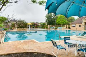 圣安东尼奥San Antonio Vacation Rental with Patio Near SeaWorld的一个带桌椅和遮阳伞的游泳池