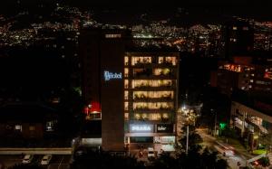 麦德林1616 Hotel Medellin的一座高大的建筑,晚上有标志