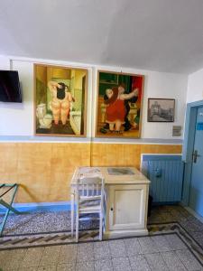 奥尔贝泰洛B&B Tony and Judy的墙上画作的房间和一张桌子