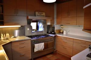 贝尼曼特利Torre de Arriba Casa Rural的厨房配有木制橱柜和炉灶烤箱。