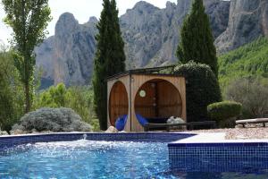 贝尼曼特利Torre de Arriba Casa Rural的一座带游泳池和凉亭的房子