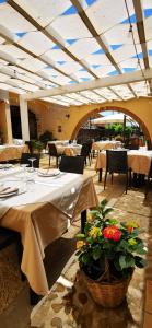 巴莱斯特拉泰Azienda Agrituristica Baglio Carta的餐厅设有桌椅,并种有鲜花