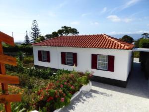 UrzelinaAzorean Cottage São Jorge的一间白色的小房子,有红色的屋顶