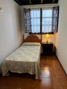 塞洛里奥Apartamentos Palombina的一间卧室设有一张床和一个窗口