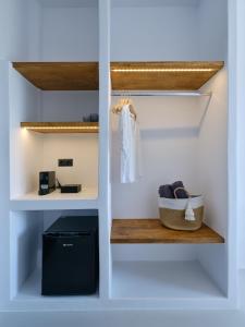 帕罗奇亚Paros Five Senses的步入式衣柜,配有白色的墙壁和木板凳
