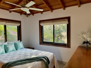 珀拉什奇亚Bella Sway Belize的一间卧室配有一张带吊扇的床和2扇窗户。