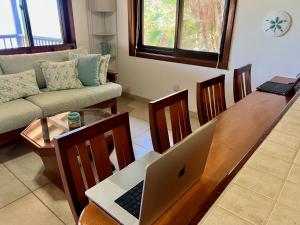 珀拉什奇亚Bella Sway Belize的客厅配有一张木制桌子上的笔记本电脑