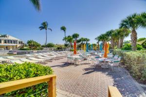 皮尔斯堡Hutchinson Island Vacation Rental with Beach Access!的一组桌椅,上面摆放着遮阳伞和棕榈树