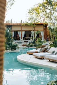 图卢姆Hotel Muaré & Spa Tulum的一座游泳池,其背景是一座度假村