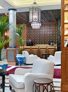马德里女王别墅H10精品酒店的一间设有白色椅子和吊灯的等候室