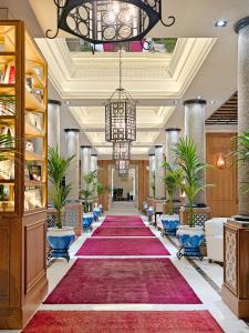 马德里女王别墅H10精品酒店的一个大大堂,配有红地毯和吊灯