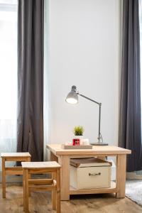 布达佩斯Paco&Orsi's homey cosy apartment in the city center的一张桌子,里面配有一盏灯和一把椅子