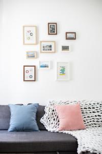 布达佩斯Paco&Orsi's homey cosy apartment in the city center的客厅配有带粉红色和蓝色枕头的灰色沙发。