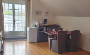 AccousChambres d hôtes La Cavalière的客房设有带桌子和冰箱的厨房。