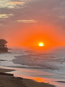 阿瓜达Aguada Beach Condos的海滩上的日落,海洋上的码头