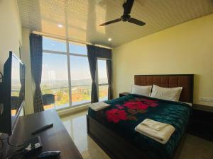 乌提Tulips Valley View Resorts的一间卧室配有一张床、一张书桌和一个窗户。