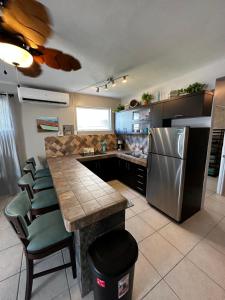 阿瓜达Aguada Beach Condos的厨房配有带椅子的柜台和冰箱。