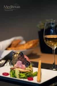 扎达尔美地特兰酒店的一份带三明治和一杯葡萄酒的白盘
