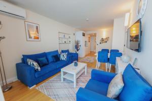 巴统ORBI CITY SUITE的客厅配有蓝色的沙发和桌子