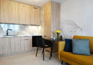 比亚韦斯托克Apartament Kraszewskiego的厨房配有桌子和黄色沙发