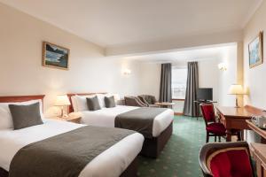 斯特兰拉尔西北城堡酒店的酒店客房配有两张床和一张书桌
