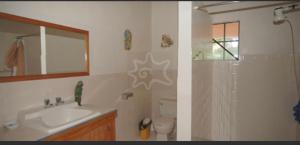 Port ElizabethThe View Villa的浴室的两张照片,配有水槽和淋浴