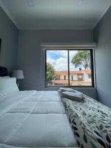 波哥大Cal Bed & Breakfast的一间卧室设有一张大床和大窗户