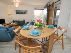 新港The Stables的用餐室以及带木桌和椅子的客厅。