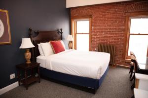Victor维克多酒店 的一间卧室设有一张床和砖墙
